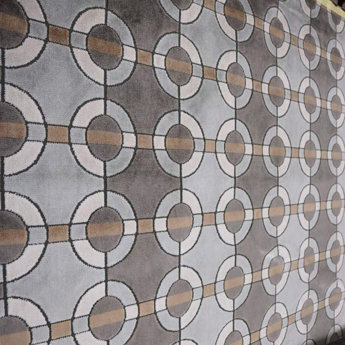 Patterned fabric with circular and rectangular shapes in gray, brown, and white.