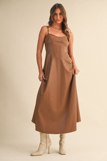 Front angled view of brown Faux Leather Corset Midi Dress with fitted corset top and flowy hem