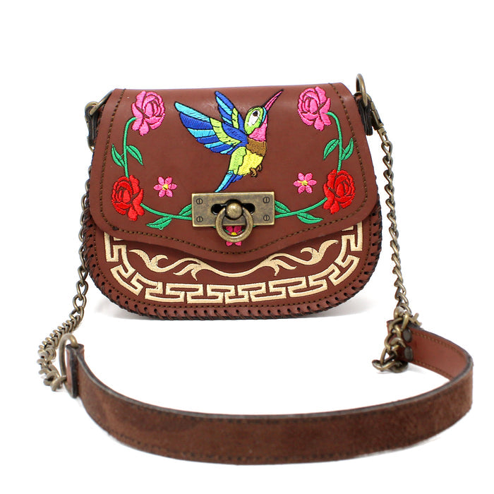 Front strap showing Brown leather handbag with colorful embroidery of a hummingbird and flowers