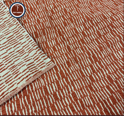 Textured fabric with a pattern of red and white lines on a brown background, featuring the brand 'Top Fabric'.