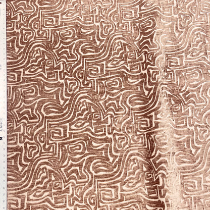 Textile with intricate brown pattern on a beige background